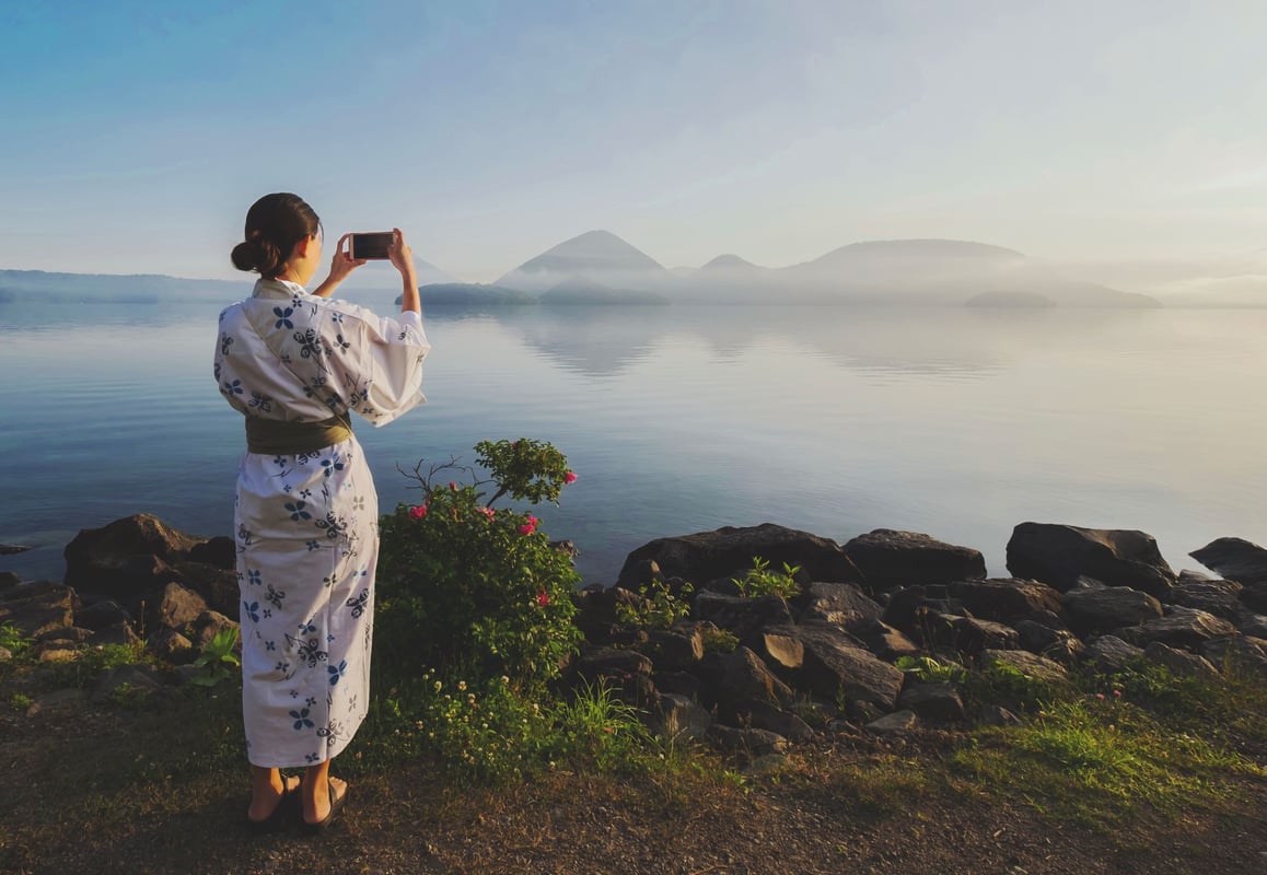 Traditionel klædt japansk pige ved Lake Toya