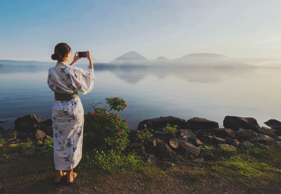 Traditionel klædt japansk pige ved Lake Toya
