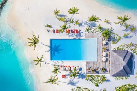 Swimmingpool omgivet af sandstrand