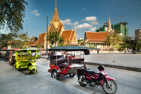Tuk tuk framför Royal Palace i Phnom Penh
