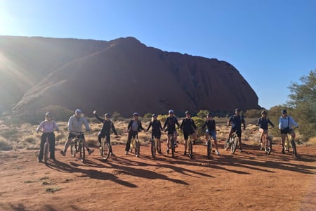Hela cykelgänget framför Uluru