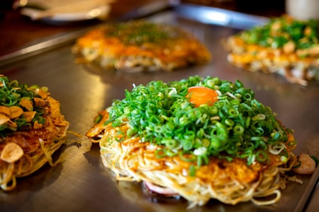 Smaka på den japanska kålpannkakan okonomiyaki