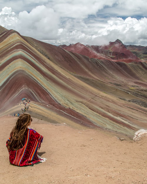 Girl looking out over rainbow mountain