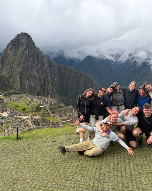 Een groep reizigers poseert bij Machu Picchu