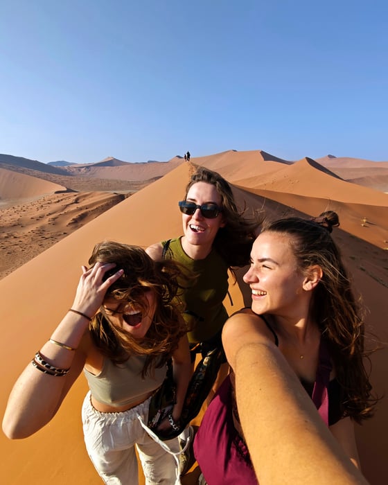 Three girls on a sand dune in Namibia