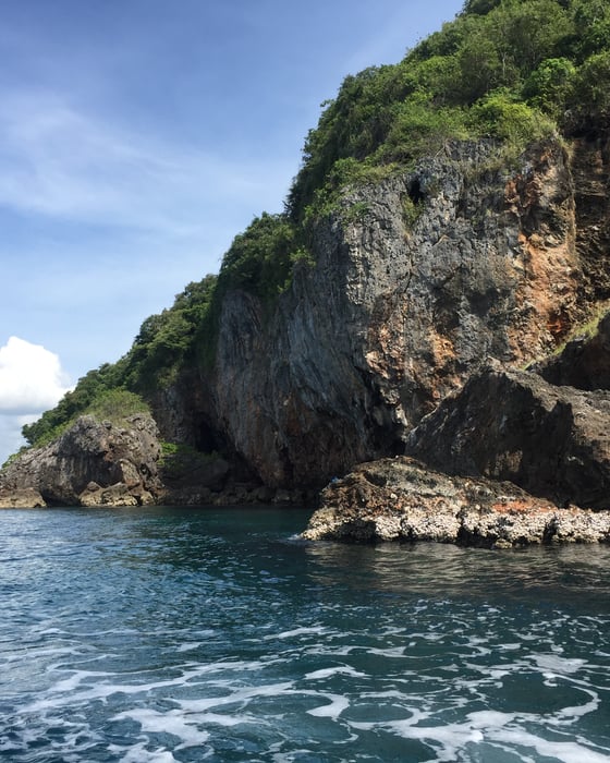 Majestic cliffs rise above sparkling blue waters