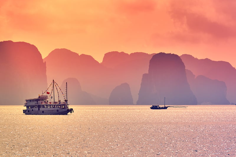 Halong Bay med skepp i solnedgången