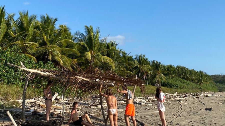 Groep mensen bouwt een schuilplaats op het strand