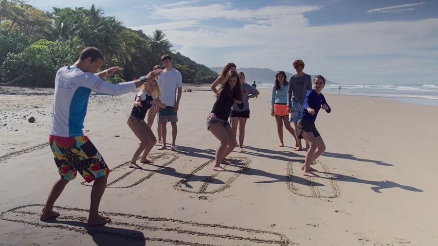 Groep mensen krijgt surfles op het strand