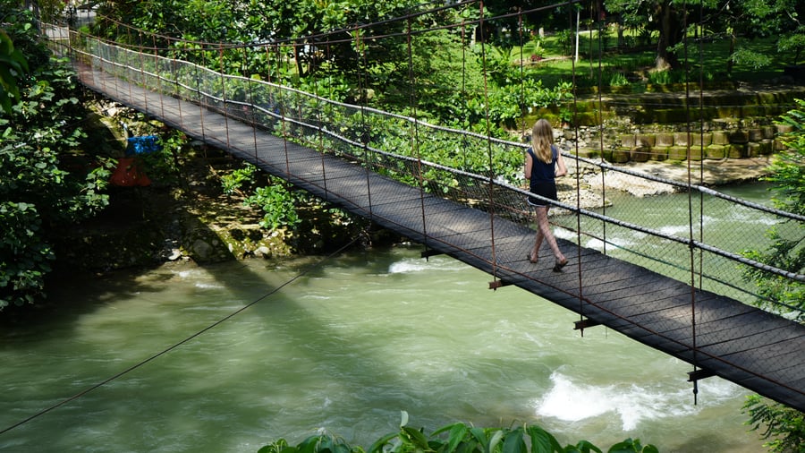 Girl walking over bridge in Sumatra
