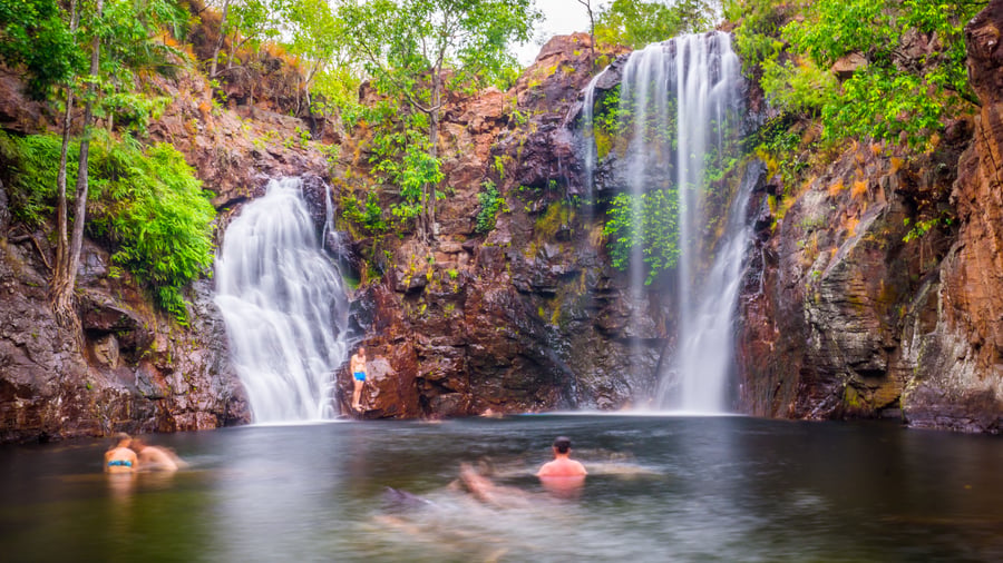 People swimming in waterfall