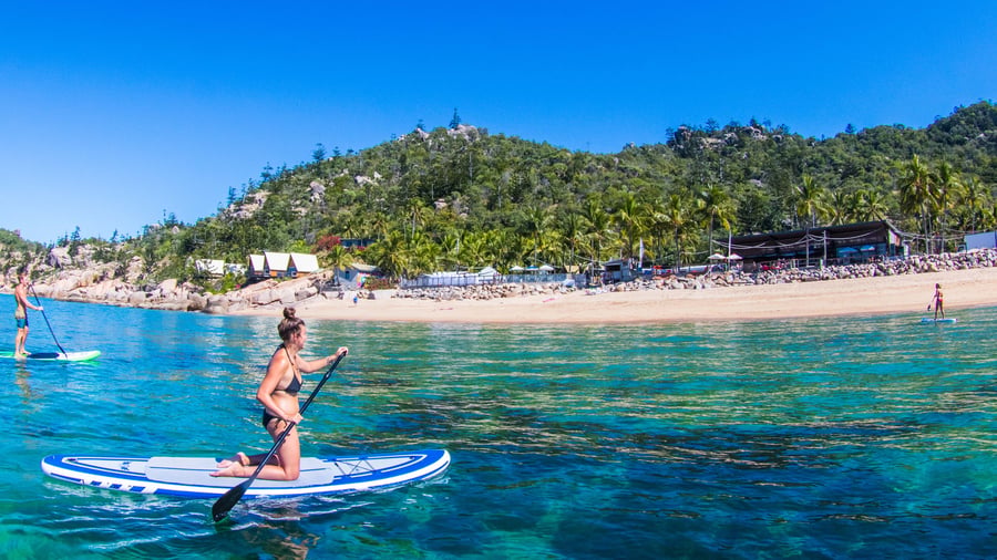 Girl on SUP board in crystal waters