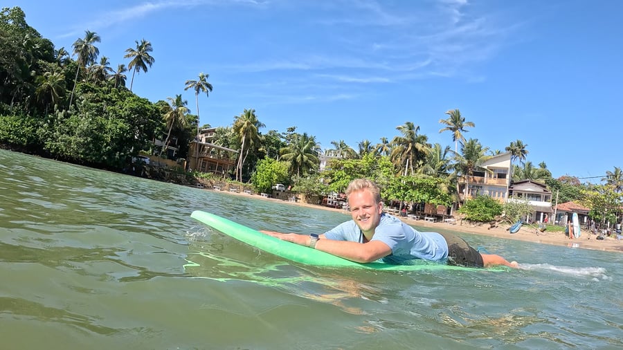 Surfer som slapper av i vannet