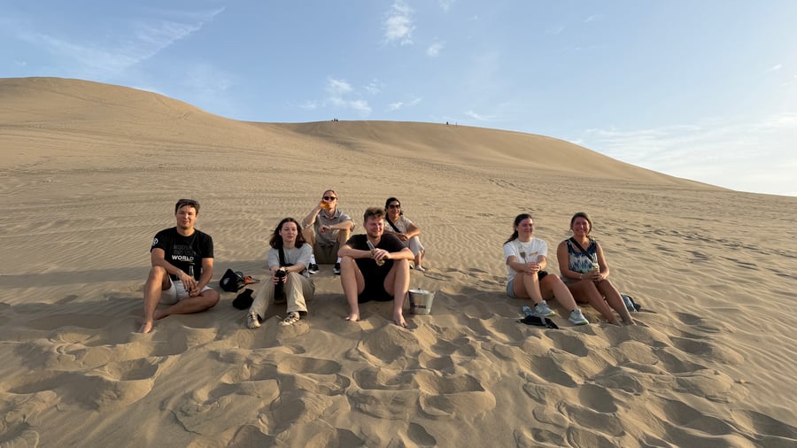 Se solen gå ner över Huacachina i öknen. 