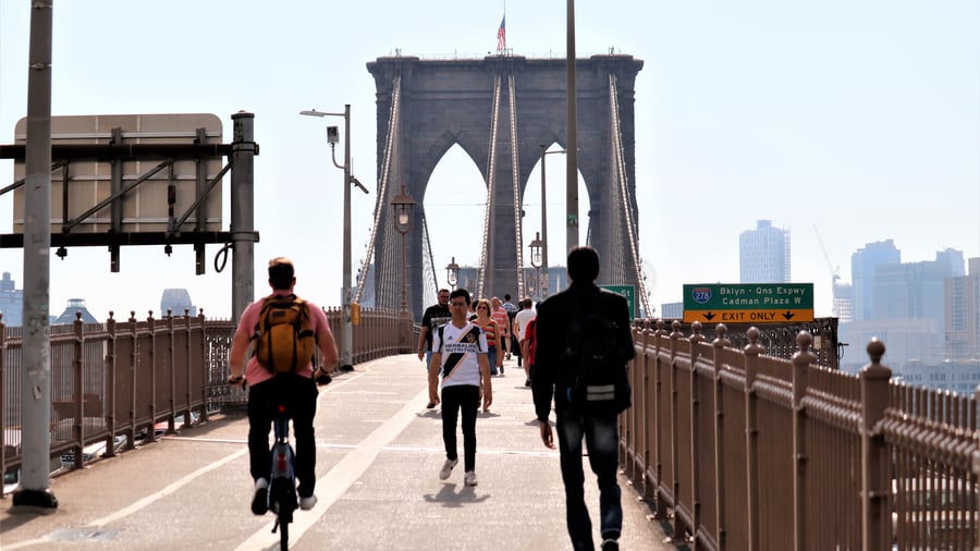 Folk som går over broen i New York