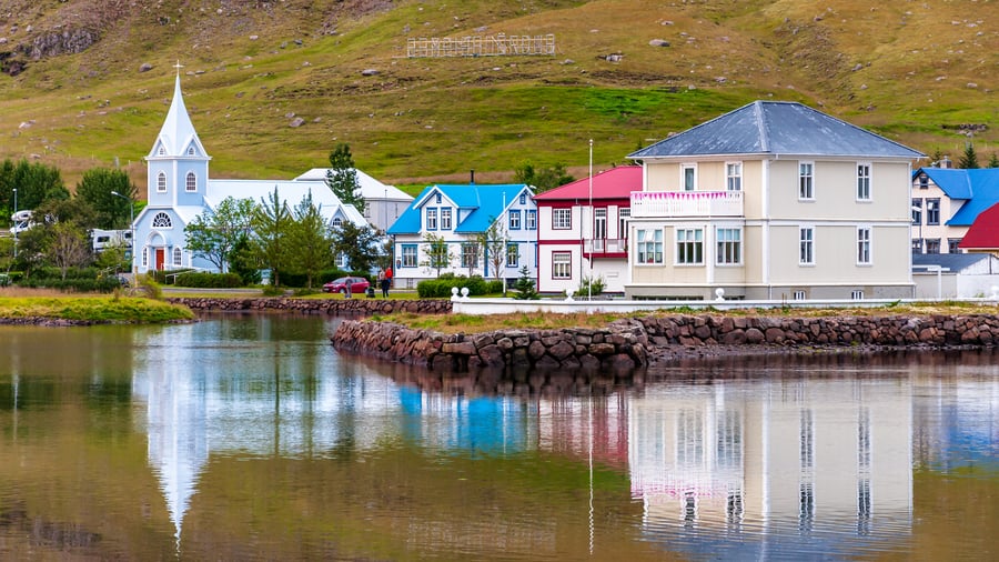 Farverige huse og kirke ved vandet i Seyðisfjörður