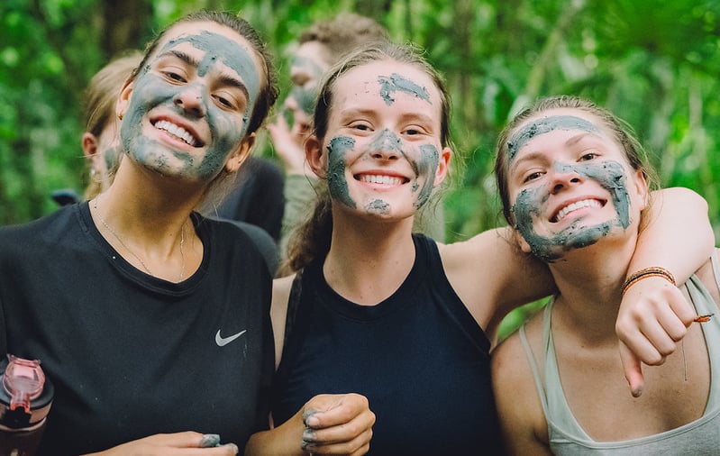 Meiden met moddermaskers in het bos
