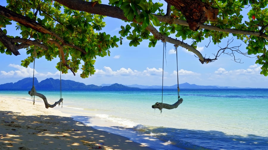 Sätt fötterna i sanden på Koh Kradan i Thailand