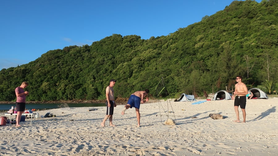 Friends enjoying a beach day under blue skies