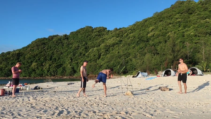 Friends enjoying a beach day under blue skies