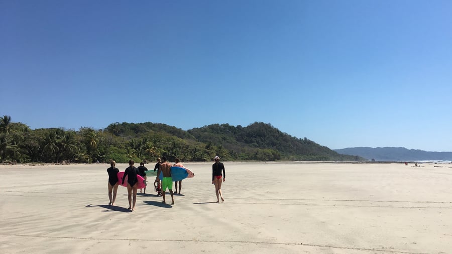 Surfers walking down the beach ready for surfing