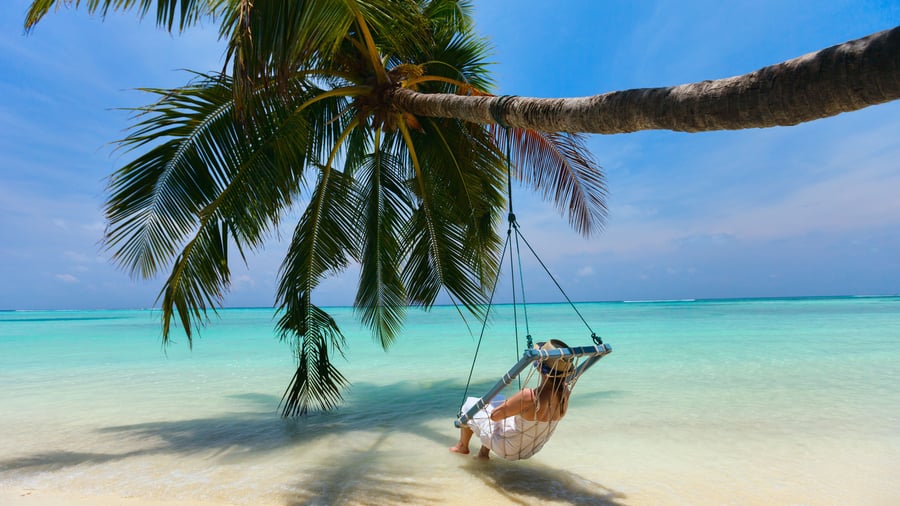 Slap af i hængekøjen på hvide strande med blåt hav