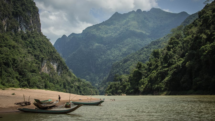 Traditional river boats and lush green mountains