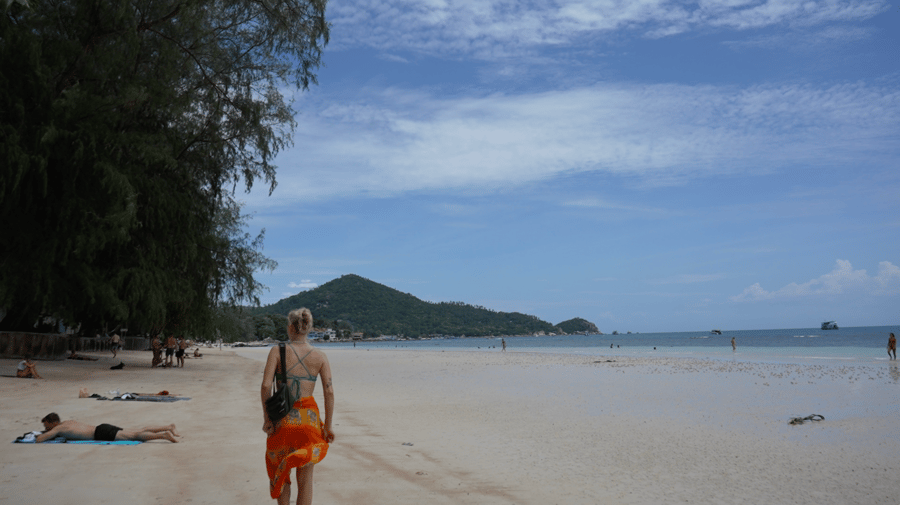 Girl walking down the beach in Thailand